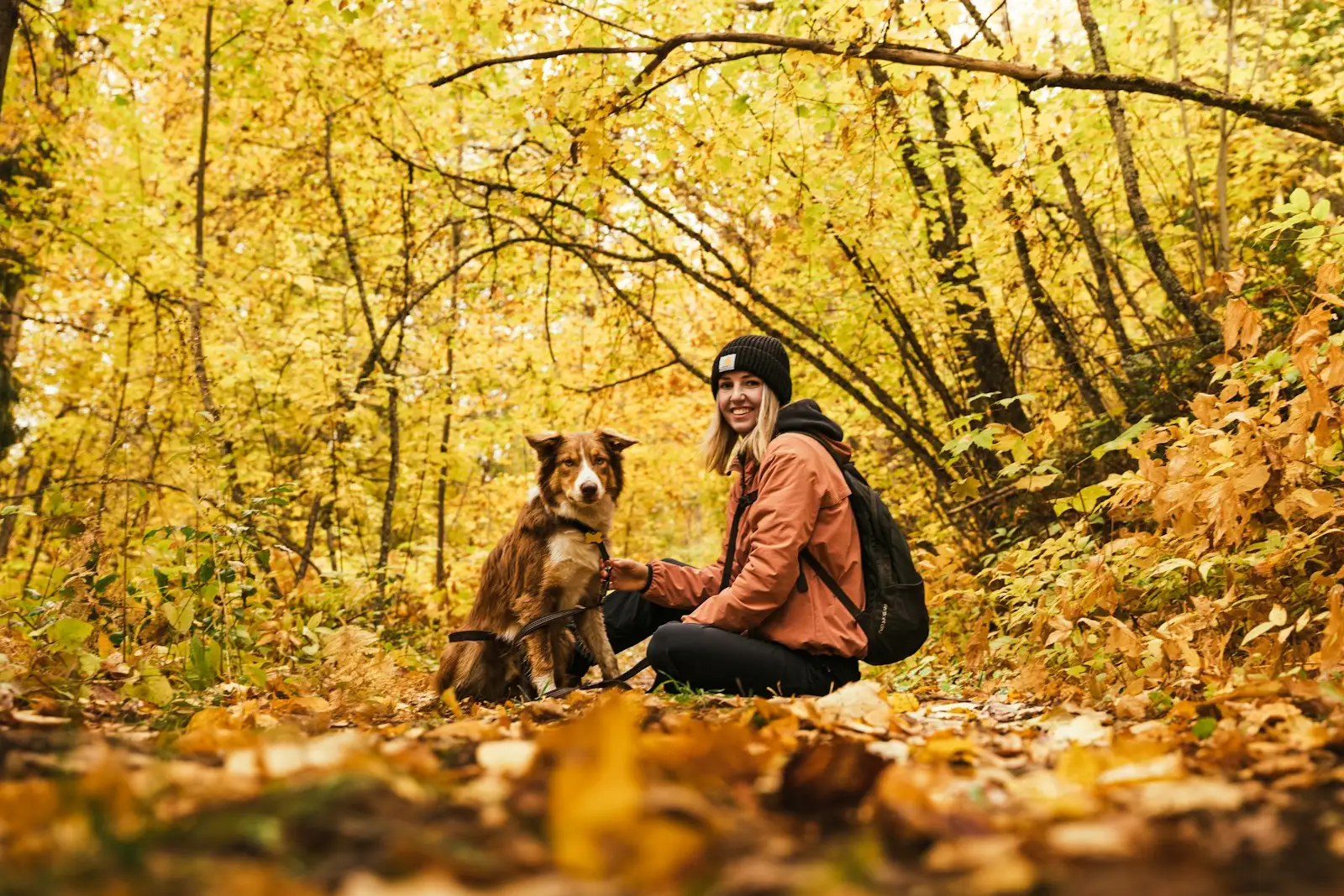 A woman sitting on the ground with her dog in British Columbia.