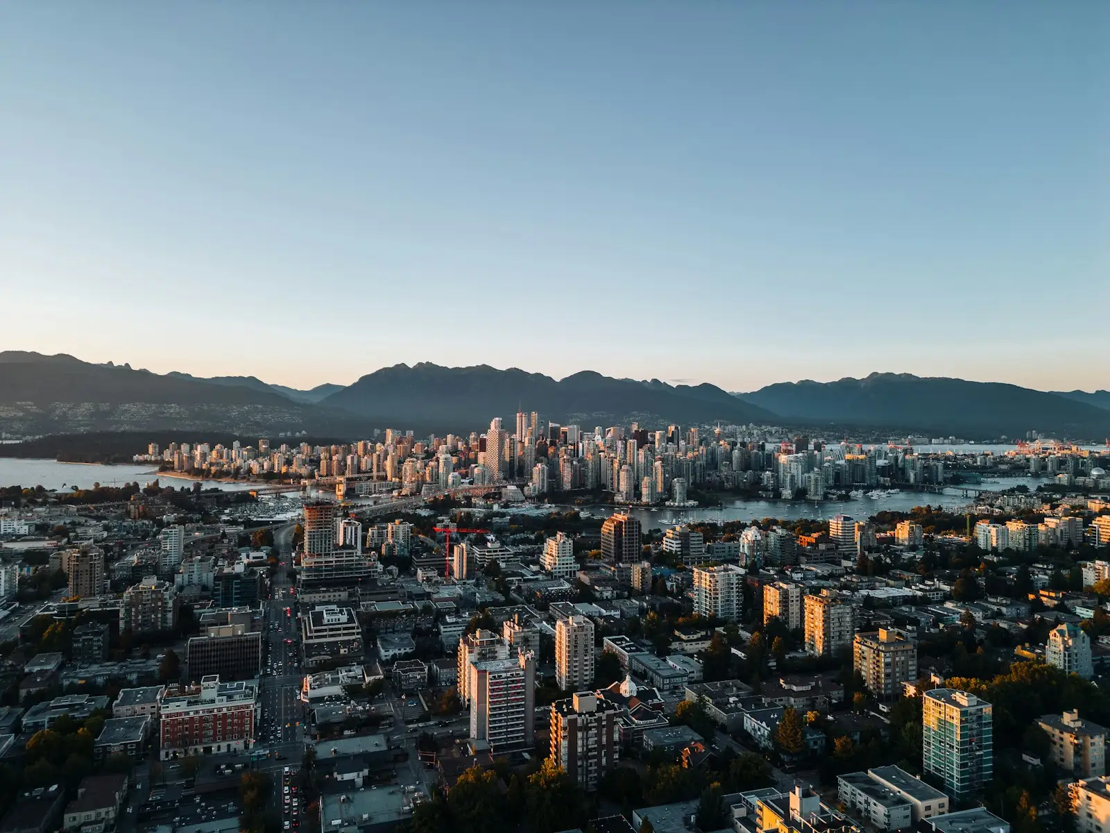 Aerial view of the Vancouver skyline against the North Shore mountains at sunset, British Columbia.